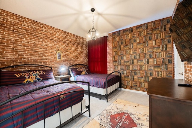 bedroom with a notable chandelier and brick wall