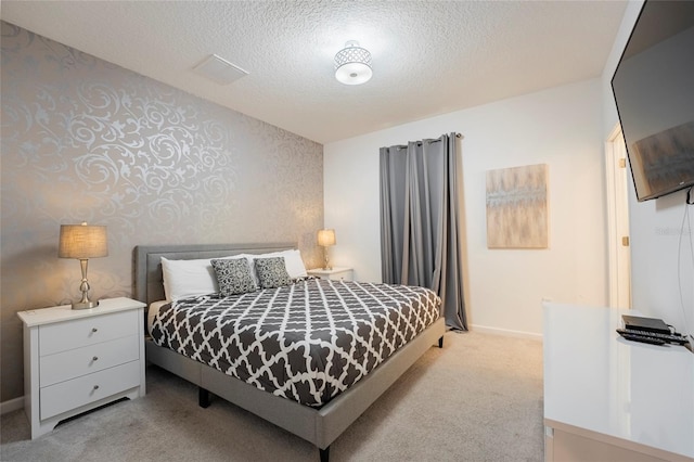 bedroom with light carpet and a textured ceiling