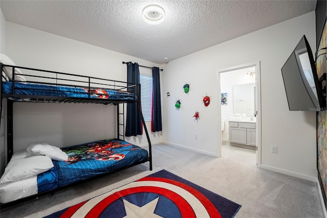 bedroom featuring light carpet, a textured ceiling, and ensuite bathroom