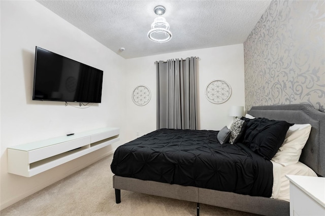 bedroom with a textured ceiling and light colored carpet