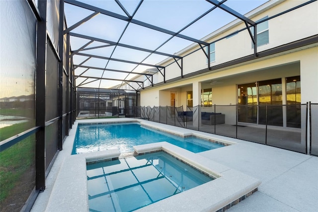 view of swimming pool with an in ground hot tub, a patio area, and a lanai