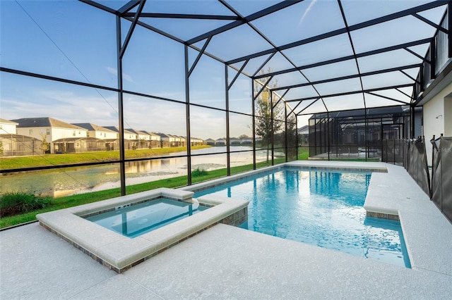 view of pool featuring a patio, a lanai, an in ground hot tub, and a water view