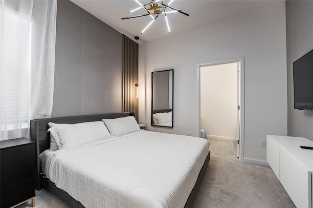 bedroom featuring light carpet and a notable chandelier