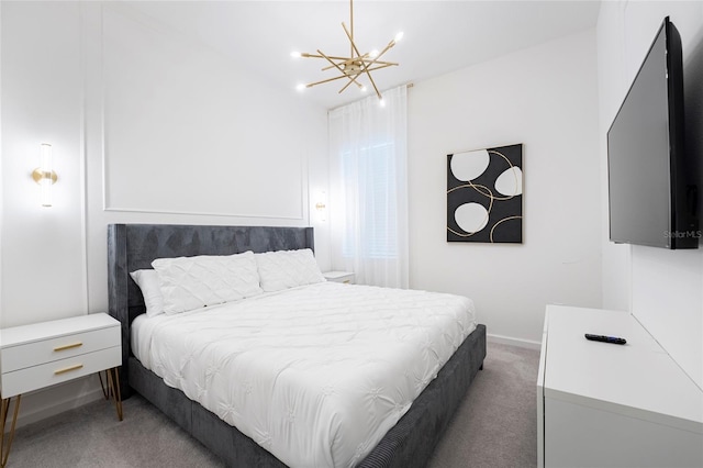 bedroom with dark colored carpet and a notable chandelier