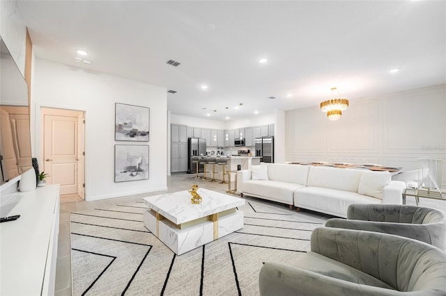 tiled living room with a notable chandelier