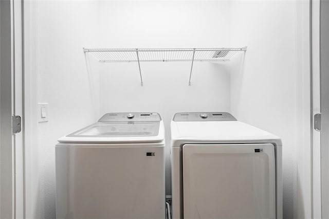 clothes washing area featuring separate washer and dryer