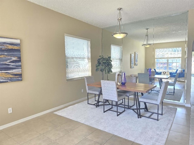 tiled dining room featuring a textured ceiling