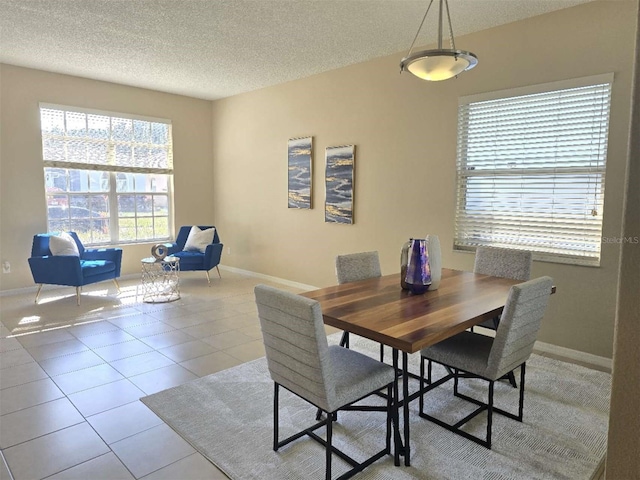 tiled dining room with a textured ceiling