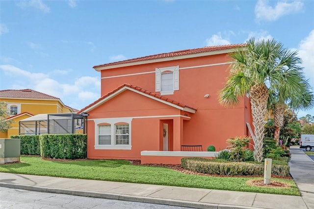 mediterranean / spanish-style home featuring glass enclosure and a front lawn