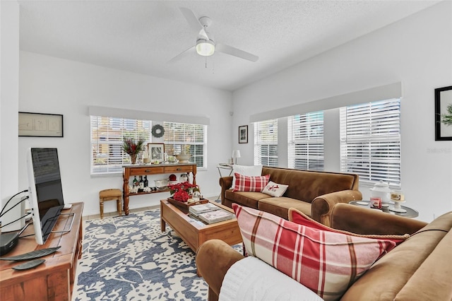 living room with plenty of natural light, ceiling fan, and a textured ceiling