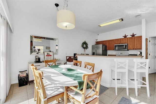 tiled dining space with a textured ceiling