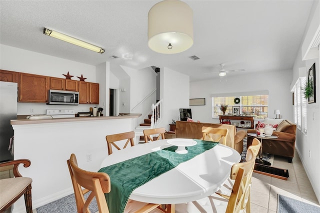 dining room with light tile patterned floors, a textured ceiling, and ceiling fan