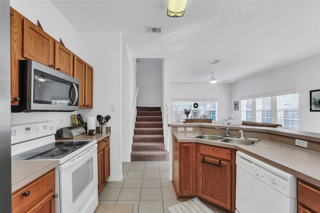 kitchen with ceiling fan, sink, a textured ceiling, white appliances, and light tile patterned floors