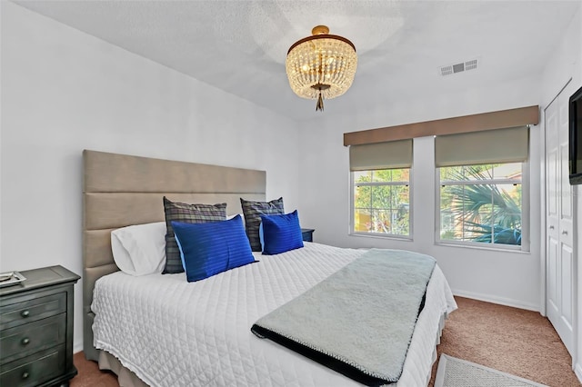 carpeted bedroom with an inviting chandelier