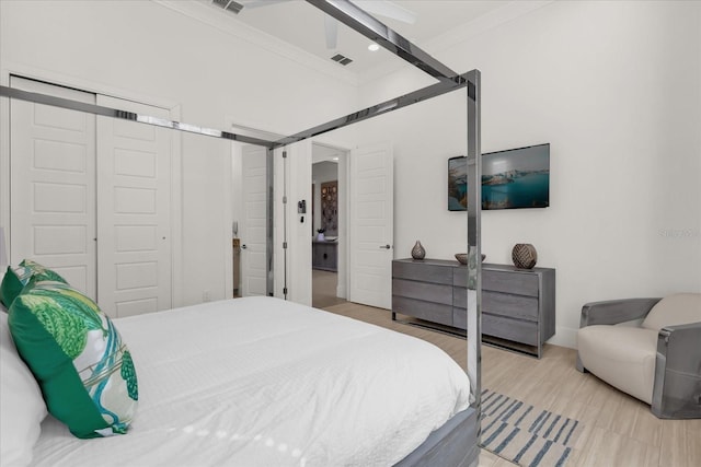 bedroom with wood-type flooring, a closet, ornamental molding, and ceiling fan