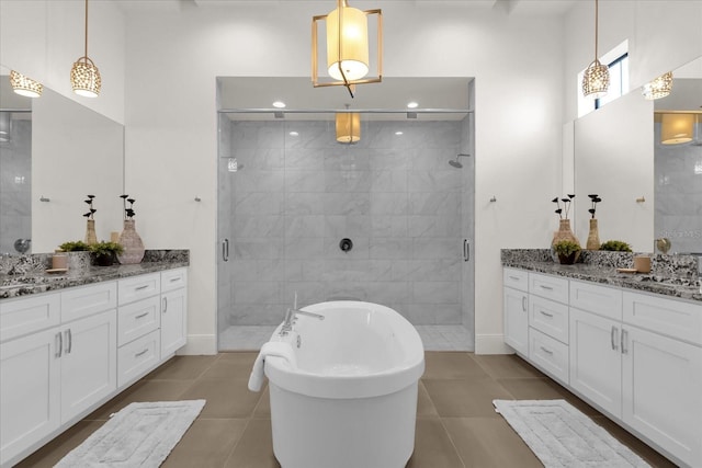 bathroom with tile patterned flooring, vanity, and separate shower and tub