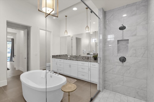 bathroom featuring tile patterned flooring, shower with separate bathtub, and vanity