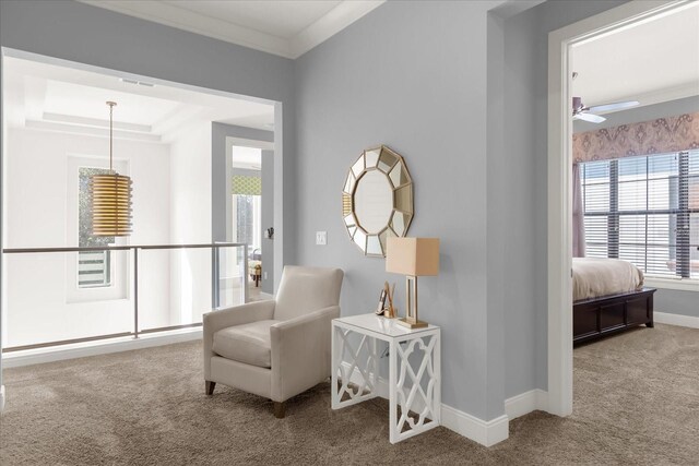 sitting room with carpet floors, ceiling fan, and ornamental molding