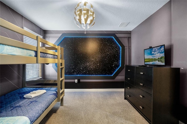 bedroom featuring a textured ceiling and light colored carpet