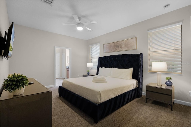 carpeted bedroom with ensuite bathroom and ceiling fan