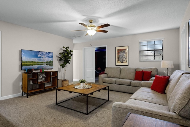 living room featuring a textured ceiling, ceiling fan, and light colored carpet