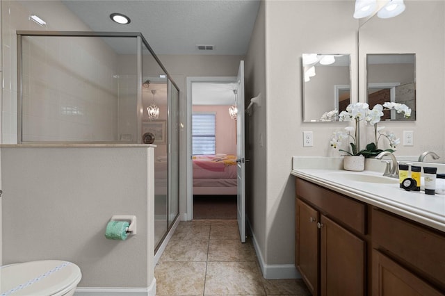 bathroom with toilet, a shower with shower door, tile patterned floors, and vanity