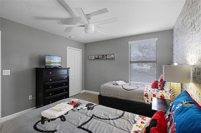 carpeted bedroom with ceiling fan and a closet