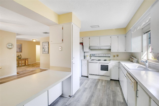 kitchen with sink, white cabinets, white appliances, light hardwood / wood-style floors, and a textured ceiling