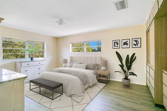 bedroom with light hardwood / wood-style flooring, a closet, and a textured ceiling