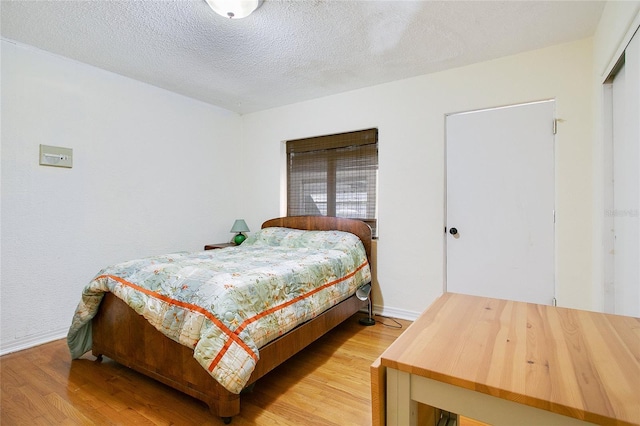 bedroom with light hardwood / wood-style flooring and a textured ceiling