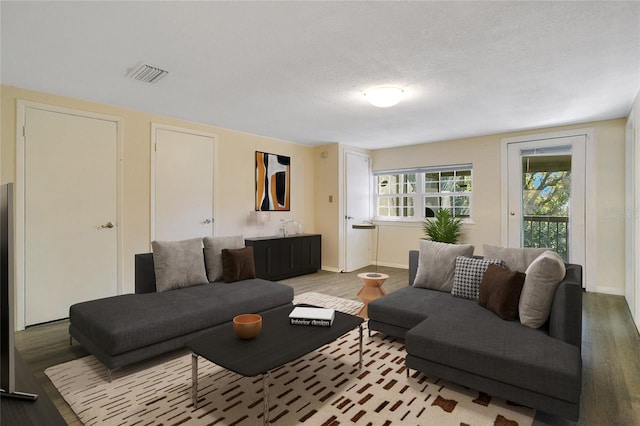 living room with hardwood / wood-style flooring and a textured ceiling