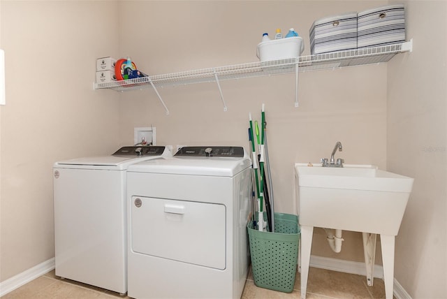 laundry area with washer and clothes dryer and light tile patterned flooring