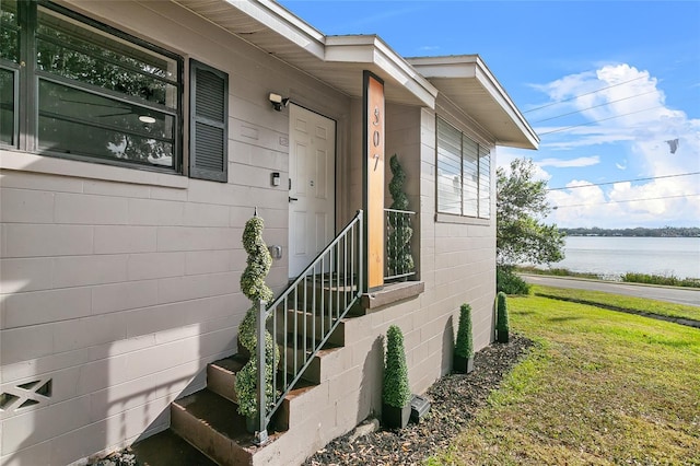 entrance to property featuring a yard and a water view