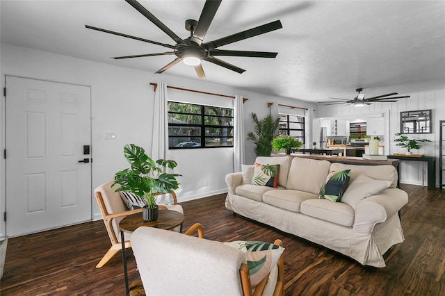 living room with dark wood-type flooring and a healthy amount of sunlight