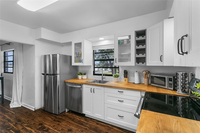 kitchen featuring wooden counters, stainless steel appliances, dark wood-type flooring, sink, and white cabinetry