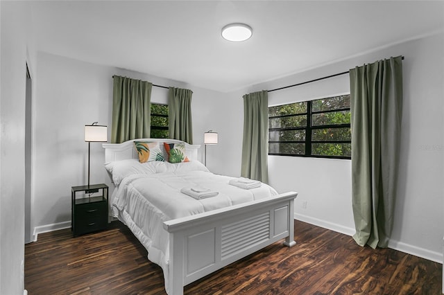 bedroom with dark hardwood / wood-style flooring