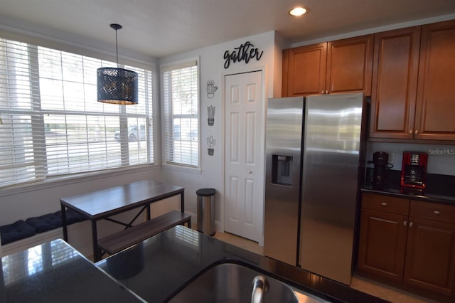 kitchen featuring decorative light fixtures and stainless steel refrigerator with ice dispenser