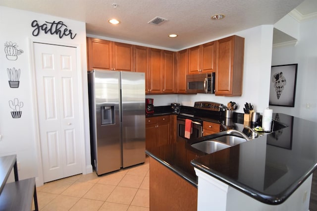 kitchen with crown molding, sink, light tile patterned flooring, kitchen peninsula, and stainless steel appliances