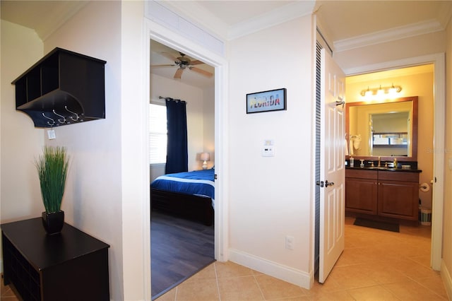 hallway featuring light tile patterned flooring, a healthy amount of sunlight, and ornamental molding