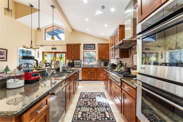 kitchen featuring dark stone counters, hanging light fixtures, sink, an island with sink, and stainless steel appliances