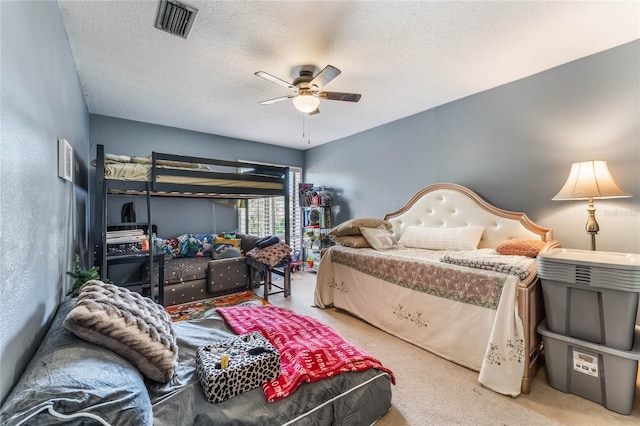 carpeted bedroom with a textured ceiling and ceiling fan