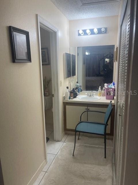 bathroom with tile patterned floors, vanity, and a textured ceiling