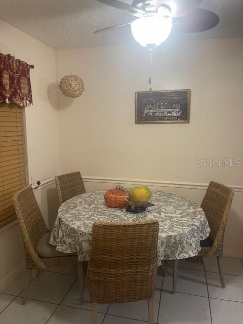 dining area with light tile patterned floors and a textured ceiling