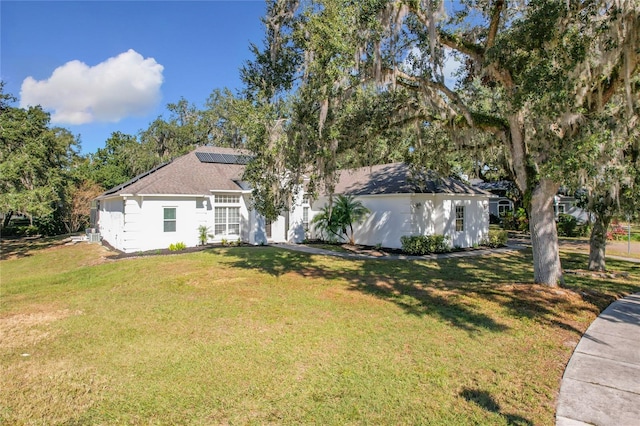 view of front of house featuring solar panels and a front yard