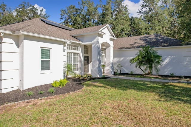 view of front of house featuring a front yard and solar panels