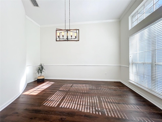 interior space featuring plenty of natural light, dark hardwood / wood-style flooring, crown molding, and a chandelier