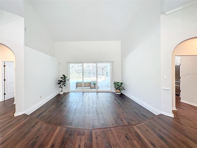 unfurnished living room with dark hardwood / wood-style floors and a high ceiling