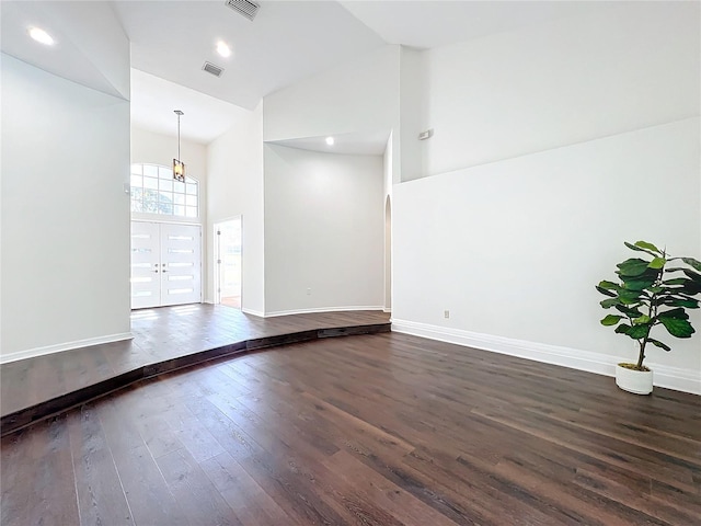 unfurnished room featuring french doors, a high ceiling, and dark hardwood / wood-style floors