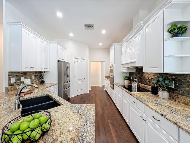 kitchen featuring white cabinets, sink, light stone countertops, tasteful backsplash, and stainless steel appliances