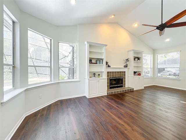 unfurnished living room featuring dark hardwood / wood-style floors, ceiling fan, lofted ceiling, and a fireplace